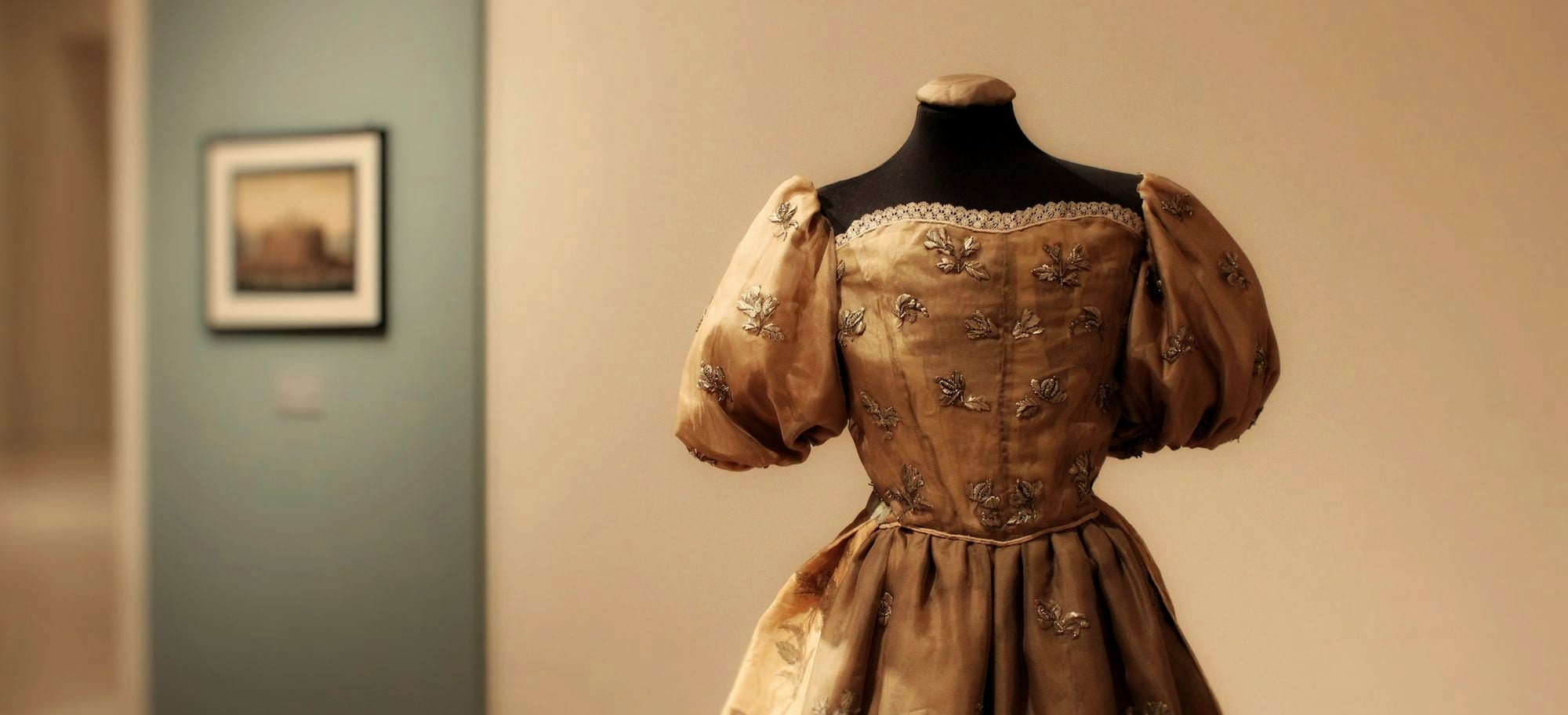 A gown on a dress form, waiting for a fitting